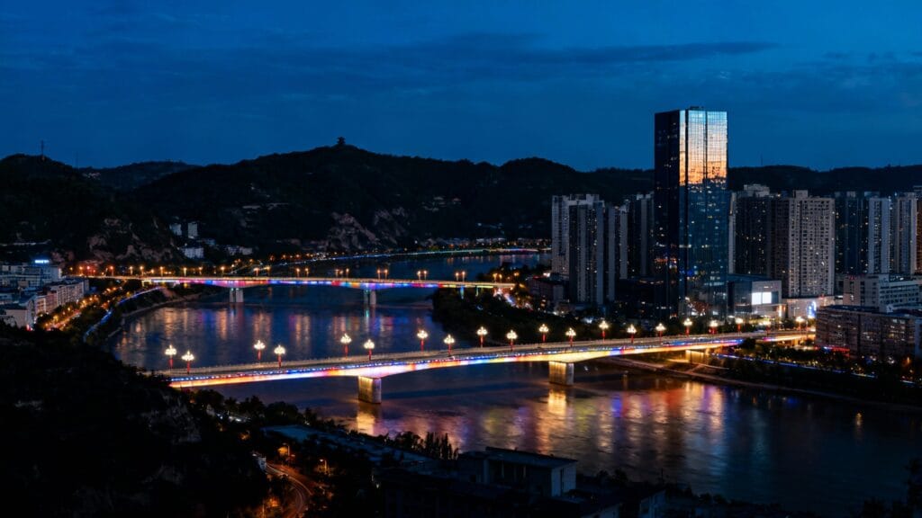 métropole vallonnée avec fleuve et ponts illuminés la nuit