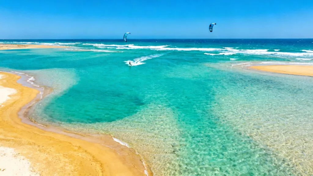 Lagune turquoise et bancs de sable avec kitesurfeurs