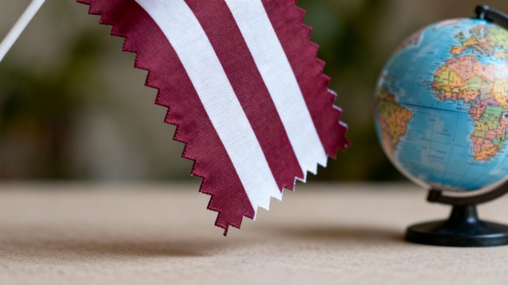 Drapeau bordeaux dentelé et globe pour repères Qatar