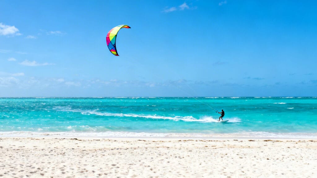Kitesurf sur grande plage, mer turquoise et vent