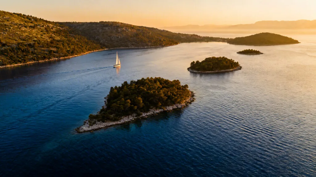Îlots adriatiques et voilier sous la lumière du soir