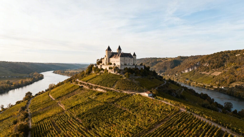 Château dominant rivière et vignobles en contrebas